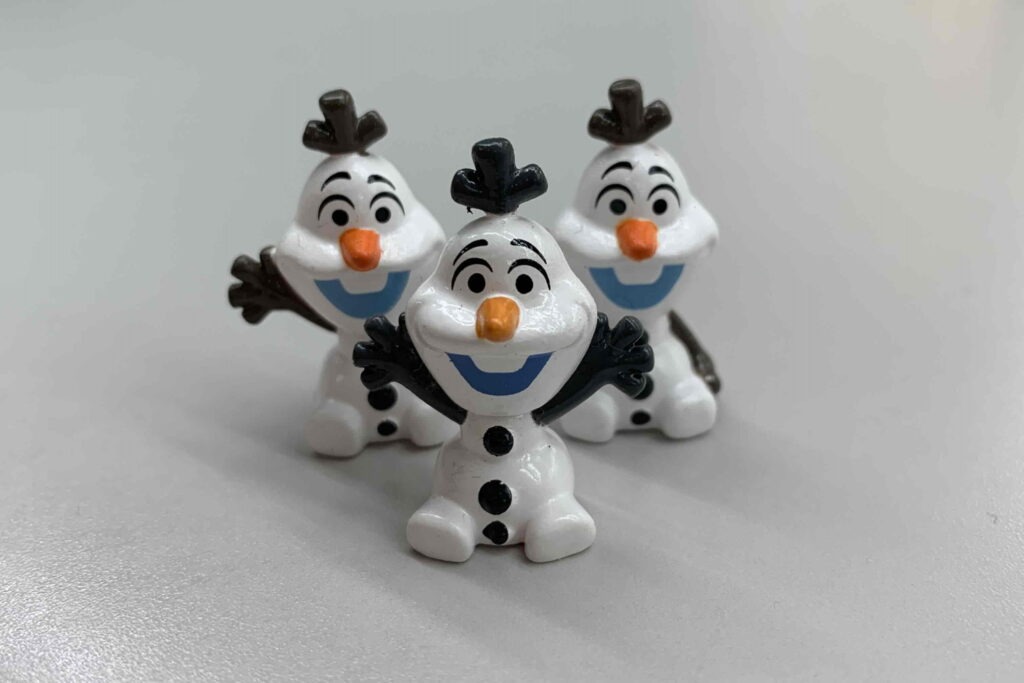 右手を挙げたオラフ2体が横に並んでいる手前に両手を挙げたオラフ1体が映っている画像